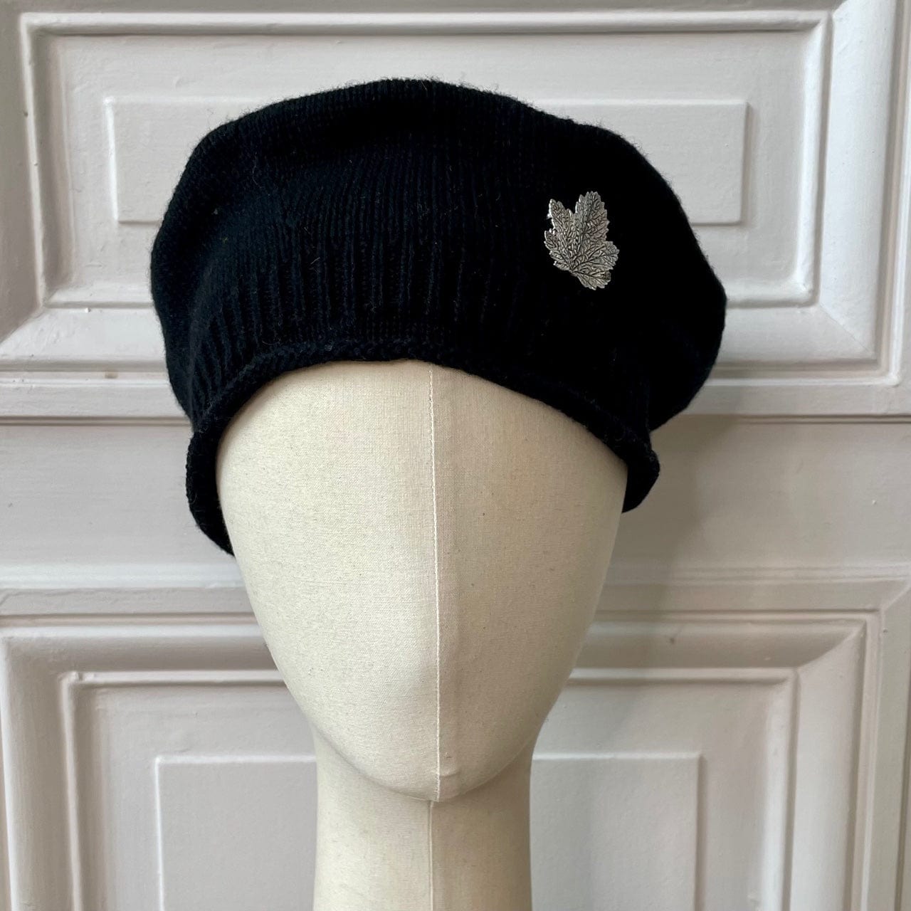 Béret bonnet noir tricoté en France 100% cachemire avec broche feuille argentée