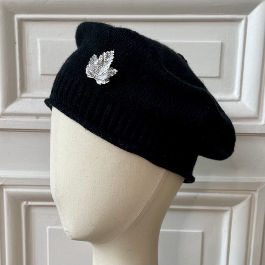 Béret bonnet noir tricoté en France 100% cachemire avec broche feuille argentée